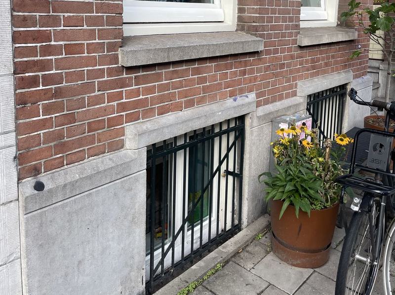 Dezelfde gevel volledig schoon na het verwijderen van graffiti in De Pijp, Amsterdam