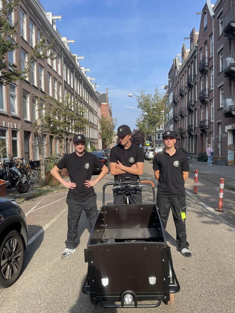 Het team van De Tuinboys met de elektrische bakfiets in een straat in Amsterdam